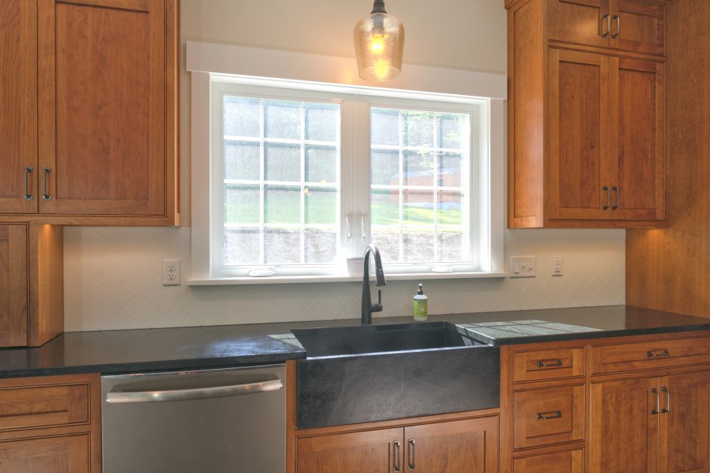 new wooden cabinets and countertop in farmhouse kitchen