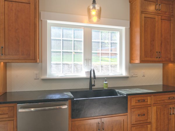 new wooden cabinets and countertop in farmhouse kitchen