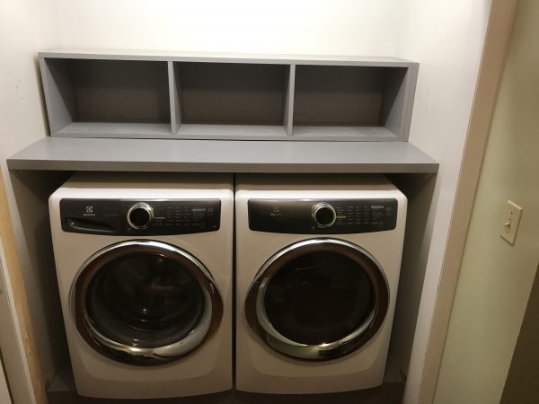 gray storage space over washing machine and dryer