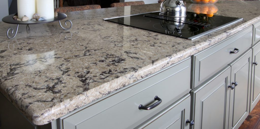 cleaning quartz countertops with brown and black speckles over green cabinets with black hardware
