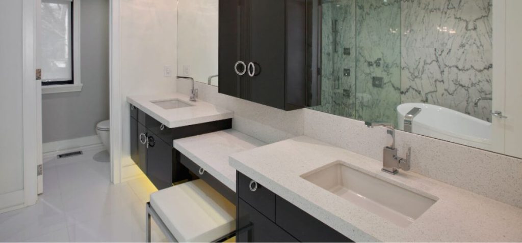 black cabinets and white speckled corian bathroom sink and countertop