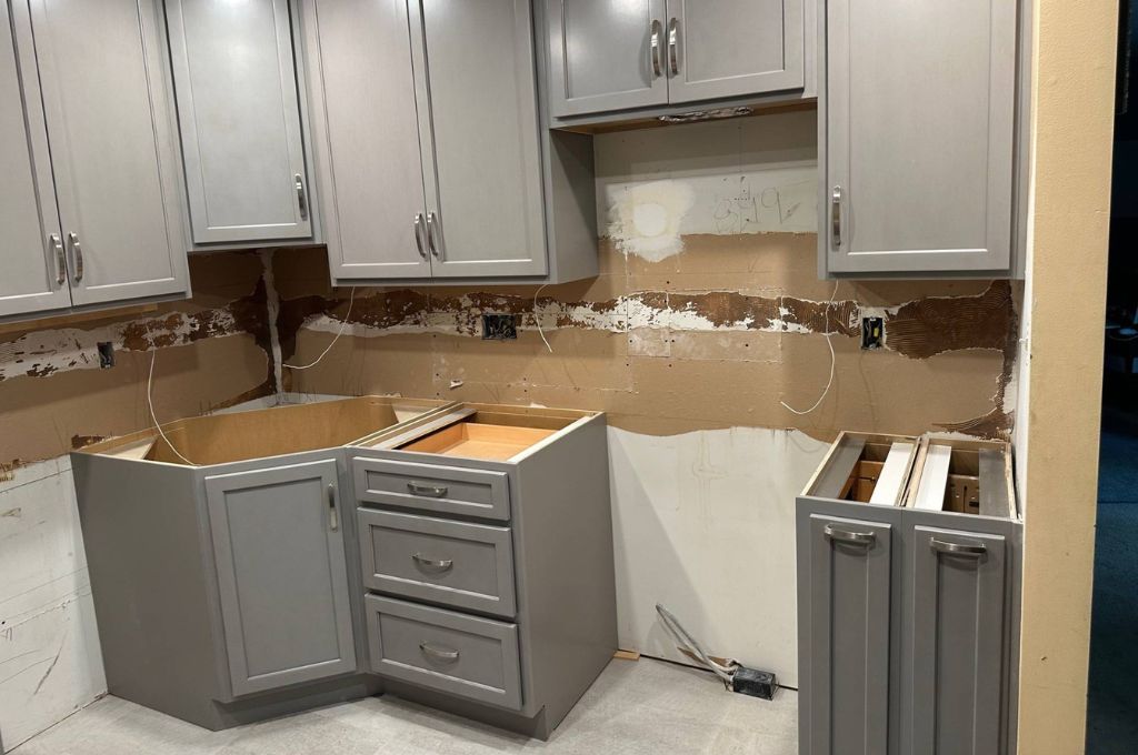gray cabinet construction project with backsplash torn out